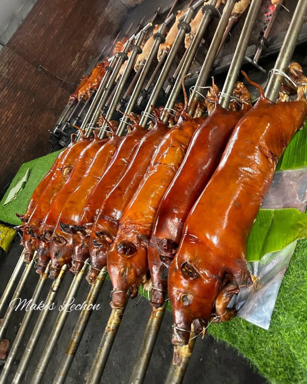 Whole lechon on bamboo spits fresh from the pit